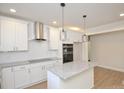 Bright, all-white kitchen featuring granite countertops, stainless appliances and central island at 307 N Catawba St, Lancaster, SC 29720