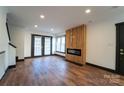 Open-concept living room with modern fireplace, hardwood floors, and lots of natural light at 3150 Driftwood Dr # B, Charlotte, NC 28205