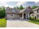 Charming home featuring a two-car garage, covered porch and a beautifully landscaped front yard at 3186 Helmsley Ct, Concord, NC 28027