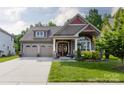 Charming home featuring a two-car garage, covered porch and a beautifully landscaped front yard at 3186 Helmsley Ct, Concord, NC 28027