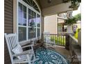 Cozy covered porch with rocking chairs, decorative pillows, and a stylish outdoor rug at 3186 Helmsley Ct, Concord, NC 28027