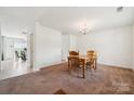 Cozy dining room featuring a wooden table with four chairs, carpet, and a chandelier at 3512 Gibbon Terrace Ct, Charlotte, NC 28269