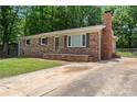Classic brick home with a spacious front yard, featuring a brick chimney and mature trees at 393 Carson Dr, Gastonia, NC 28052