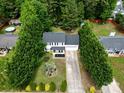 An aerial view showcasing a home with mature trees, well-maintained lawn, long driveway, and neighborhood at 4332 Bathurst Dr, Charlotte, NC 28227