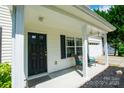 A cozy front porch with black door, classic white trim, and a seating area at 4332 Bathurst Dr, Charlotte, NC 28227