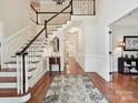 Grand foyer with hardwood floors, staircase, wainscoting, and decorative rug at 4701 Pineland Pl, Charlotte, NC 28277