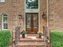 Elegant double front door with glass inserts, flanked by sconces and planters at 4701 Pineland Pl, Charlotte, NC 28277