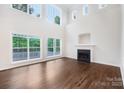 Bright living room with a fireplace, hardwood floors and large windows offer natural light and scenic views at 5745 Snapdragon Ln, Huntersville, NC 28078