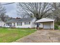 Charming single-story home featuring a carport, well-maintained lawn, and a welcoming entryway with iron railings at 6323 Wilora Lake Rd, Charlotte, NC 28212