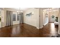 Elegant dining room featuring hardwood floors, modern chandelier, and wainscoting detail at 6618 Vizcaya Ct, Charlotte, NC 28226