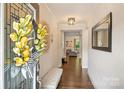 Inviting home entryway with hardwood floors, neutral paint, decorative wreath, and a glimpse into the living area at 6618 Vizcaya Ct, Charlotte, NC 28226