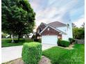 Beautiful two-story brick home with green lawn, mature trees, and an attached two-car garage at 8218 Lynnewood Glen Dr, Charlotte, NC 28269