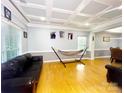 Bright living room featuring a hammock, tray ceiling, hardwood floors, and neutral paint at 8218 Lynnewood Glen Dr, Charlotte, NC 28269