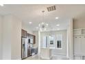 Open-concept living area with modern lighting fixtures, stainless steel appliances, and light wood flooring at 838 Van Every St, Charlotte, NC 28205