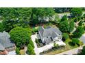 Aerial back view of the home showing the rear patio, yard and basketball court in the landscaping at 8707 Fairview Rd, Charlotte, NC 28226