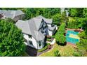 Aerial view of the home showing the gray roof and a basketball court on the meticulously landscaped property at 8707 Fairview Rd, Charlotte, NC 28226