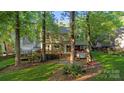 Spacious backyard featuring a large deck, mature trees, and ample green space at 9002 Maple Hill Ct, Huntersville, NC 28078