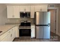 Bright kitchen featuring stainless steel appliances, granite countertops, and white cabinets at 951 Hardin Dr, Shelby, NC 28150