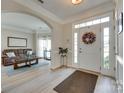 Inviting entryway with light wood flooring, arched doorways, and views into the living room at 9700 Stewart Spring Ln, Charlotte, NC 28216