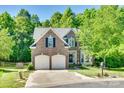 Attractive brick home with a two-car garage, lush green lawn, mature trees, and a cul-de-sac street at 9700 Stewart Spring Ln, Charlotte, NC 28216