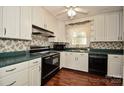 Bright kitchen featuring white cabinets, black appliances, laminate countertops and wood flooring at 1004 Midwood Dr, Monroe, NC 28112