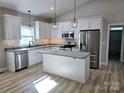 Modern kitchen with white cabinetry, stainless appliances, and a center island at 107 Skyland Dr, Mount Gilead, NC 27306