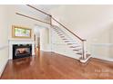 Spacious living room features a staircase, fireplace, wood flooring, and natural light at 1161 Stuarts Landing Dr, Cramerton, NC 28032