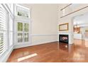 Sun-drenched living room boasts a soaring ceiling, fireplace, wood floors, and large windows with plantation shutters at 1161 Stuarts Landing Dr, Cramerton, NC 28032