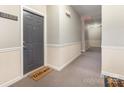 Hallway leading to unit door with clean neutral paint and a 'Welcome' mat at 11707 Ridgeway Park Dr, Charlotte, NC 28277