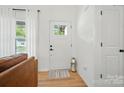 Bright entryway with a wood-look floor, white door, and natural light from a window at 1212 Mason Way, Mount Holly, NC 28120
