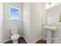 Bathroom featuring a pedestal sink, white toilet, and a window with natural light at 1359 Russell St, Rock Hill, SC 29730