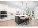 Modern kitchen with an island that has seating, white cabinets, and stainless appliances at 1359 Russell St, Rock Hill, SC 29730