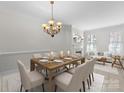 Elegant dining room with a large wooden table, chandelier, and a cozy fireplace at 155 Harper Lee St, Davidson, NC 28036