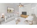 Bright living room boasts a modern design with a plush sofa and a stylish ceiling fan at 155 Harper Lee St, Davidson, NC 28036