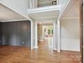 Spacious foyer featuring hardwood floors, decorative wall paneling, and elegant columns leading to adjoining rooms at 16319 Ashlyn Chase Ct, Charlotte, NC 28277