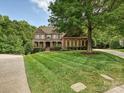 Beautifully landscaped home with lush green lawn, mature trees, and a classic brick exterior at 16319 Ashlyn Chase Ct, Charlotte, NC 28277