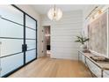Bright foyer featuring wood floors, a modern chandelier, and view of a bathroom at 1719 Shoreham Dr, Charlotte, NC 28211