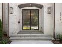 Elegant front door with a brick surround, and sconces on either side at 1719 Shoreham Dr, Charlotte, NC 28211