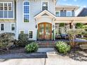Gorgeous wood double door entrance with covered porch and manicured landscaping for enhanced curb appeal at 1900 Nassau Blvd, Charlotte, NC 28205