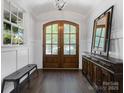 Elegant front foyer showcasing hardwood floors, arched doorways, and a decorative mirror, creating a warm ambiance at 1900 Nassau Blvd, Charlotte, NC 28205