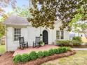 Charming white brick home featuring a cozy front porch with rocking chairs and manicured landscaping at 2110 Winter St, Charlotte, NC 28205
