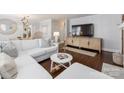 Bright living room with hardwood floors, white sectional sofa, TV and decorative cabinet at 2110 Winter St, Charlotte, NC 28205