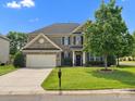 Charming brick home with a lush green lawn, mature trees, and a well-maintained garden at 2467 Chatham Dr, Fort Mill, SC 29707