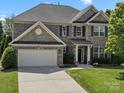 Two-story brick home with a well-manicured lawn, two-car garage, and beautiful landscaping at 2467 Chatham Dr, Fort Mill, SC 29707