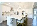 Bright kitchen features a large island, white cabinets, stainless steel appliances, and modern lighting at 262 Country Lake Dr, Mooresville, NC 28115