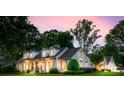 Elegant exterior view of a white brick home at dusk, showcasing the architecture and manicured landscaping at 2900 Wickersham Rd, Charlotte, NC 28211