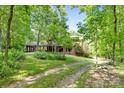 View of a brick house with a carport and landscaped front yard, showcasing its curb appeal at 332 York Spann Rd, Hamptonville, NC 27020