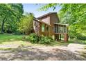 Rear view of brick house with a screened porch and a natural landscape with mature trees at 332 York Spann Rd, Hamptonville, NC 27020