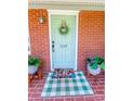 Close up of a charming front door with a wreath, welcome mat, and potted plants at 539 30Th Nw Ave, Hickory, NC 28601