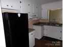 Functional kitchen with white cabinetry and black appliances at 556 Roundtree Cir, Chester, SC 29706